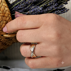 
                  
                    Model wearing a three-tone multiband ring near a lavender bouquet
                  
                