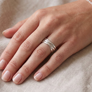 
                  
                    Sterling silver interlocking circle ring with multiple bands, worn on finger.
                  
                