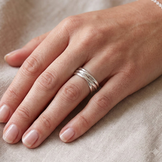 Sterling silver interlocking circle ring with multiple bands, worn on finger.