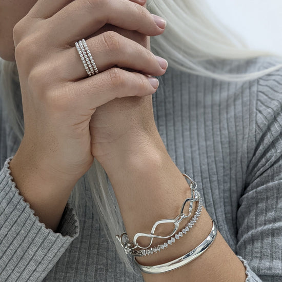 
                    
                      Sterling silver jewellery look — triple beaded ring styled with layered infinity link bracelet, tennis bracelet and chunky bangle
                    
                  