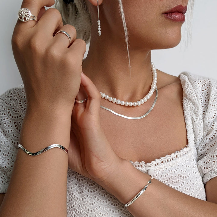 Sterling silver hammered wavy bangle styled with pearl jewellery set, tree of life ring and herringbone necklace