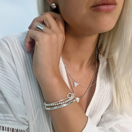 
                    
                      Sterling silver dome huggies styled with love knot bangle, ball bracelet and wide band ring
                    
                  