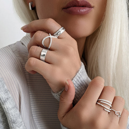 
                    
                      Sterling silver rings styled together on both hands — hammered, crossover pavé, chunky band, multi-row pavé and heart designs
                    
                  