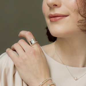 
                  
                    Close-up of chunky sterling silver ring with wide rippled design
                  
                