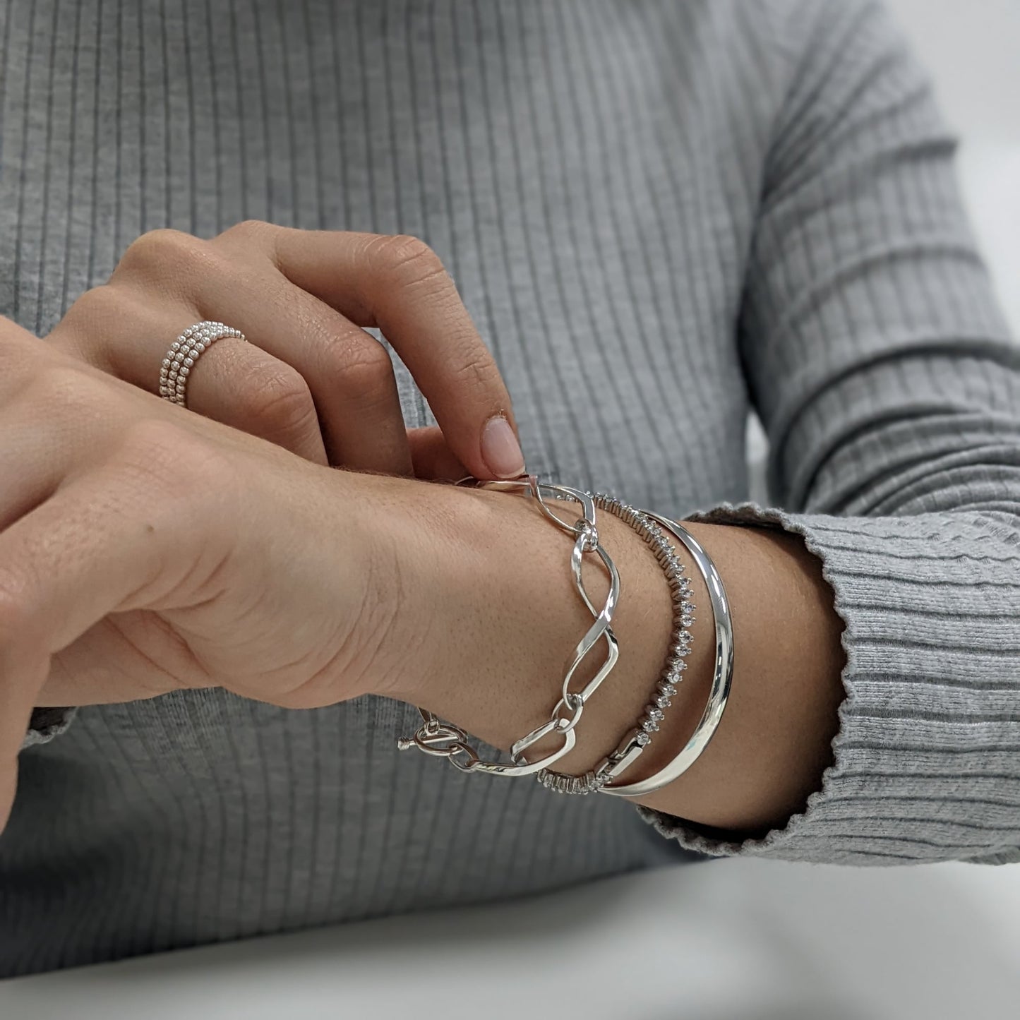 925 silver jewellery set: beaded stacking rings, infinity link bracelet, CZ tennis bracelet, and D-shape bangle