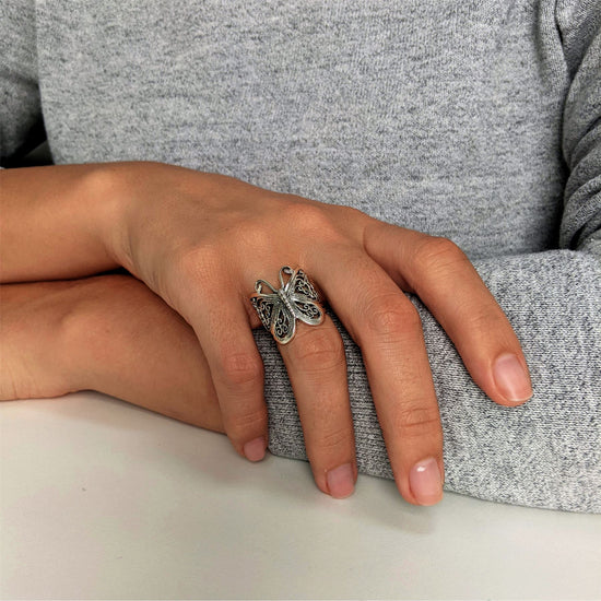 
                    
                      Close-up of filigree cut-out butterfly motif on sterling silver Y2K statement ring
                    
                  