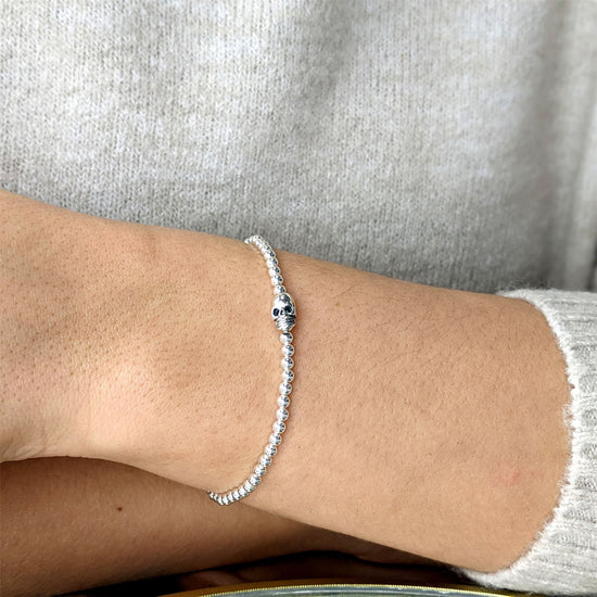 
                    
                      Close-up of sterling silver skull charm on ball bead stretch bracelet
                    
                  