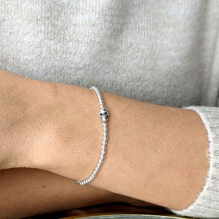 Close-up of sterling silver skull charm on ball bead stretch bracelet