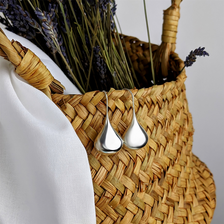 Close-up of sterling silver puffed teardrop dangle earrings