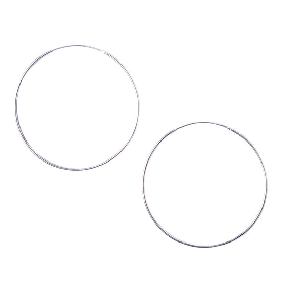 Two large sterling silver sleeper hoop earrings against a white background