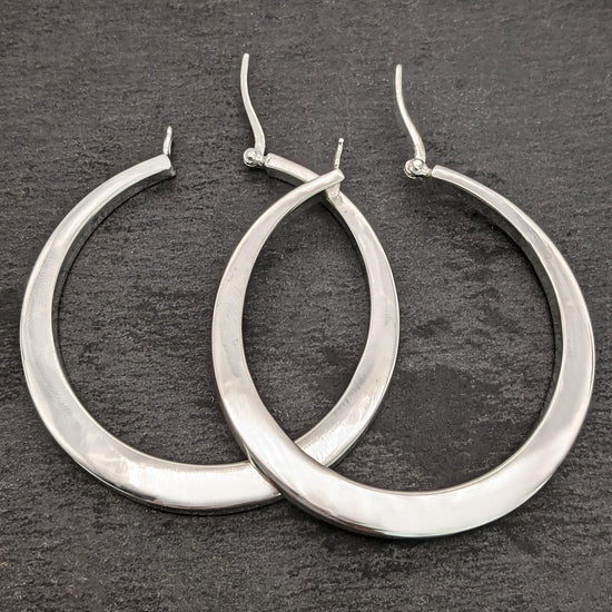 
                    
                      Close-up of large chunky 925 silver hoop earrings with a polished finish
                    
                  