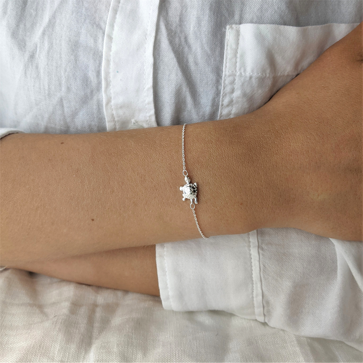 Woman wearing a sterling silver turtle chain bracelet