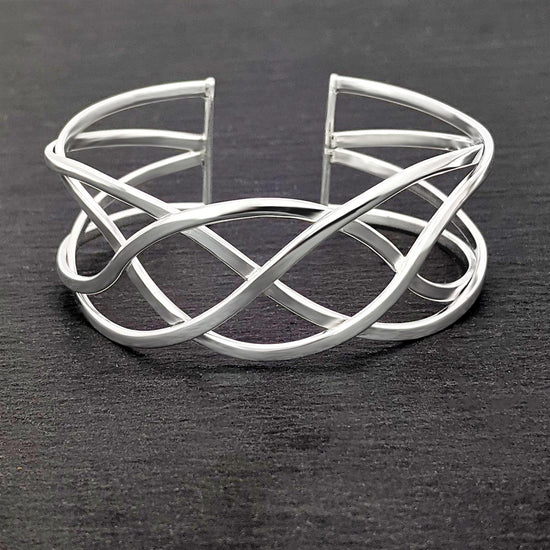 
                    
                      Close-up of sterling silver Celtic knot bangle with intricate braided knotwork
                    
                  