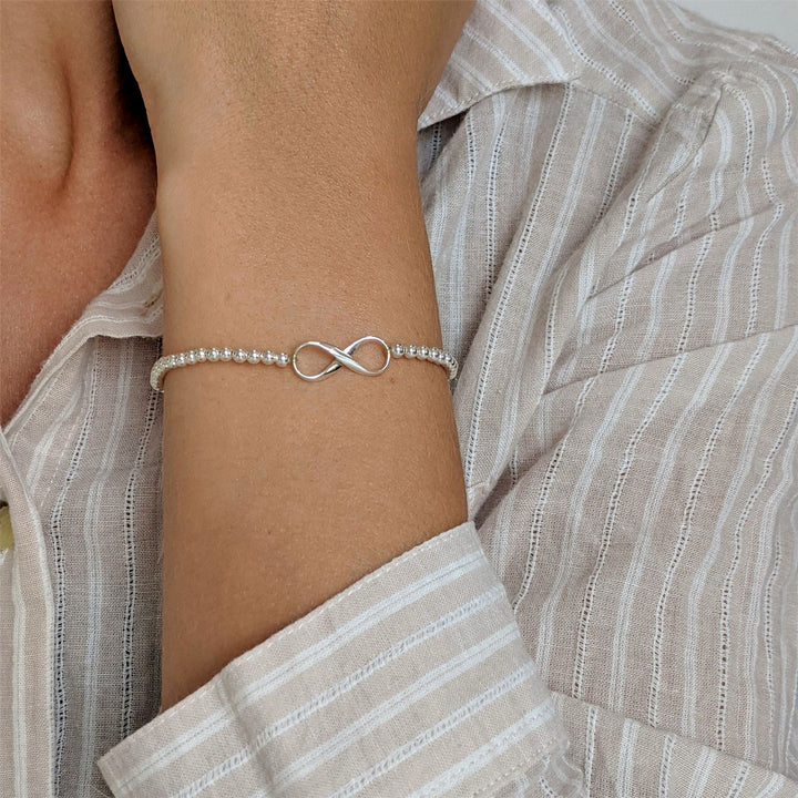 Sterling silver infinity beaded stretch bracelet worn on wrist